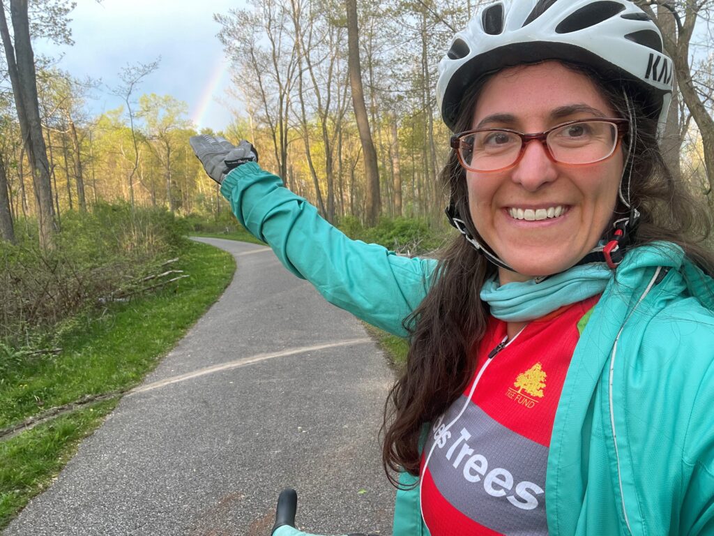 Lisa pausing on a bike ride to admire a rainbow after spring storm
